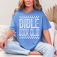 Model wearing a Comfort Colors 1717 T-Shirt in muted blue-green (mystic blue) featuring a distressed large word graphic that says, "Bible Book Club" Racer checkered stripes are on the top and bottom of the print.