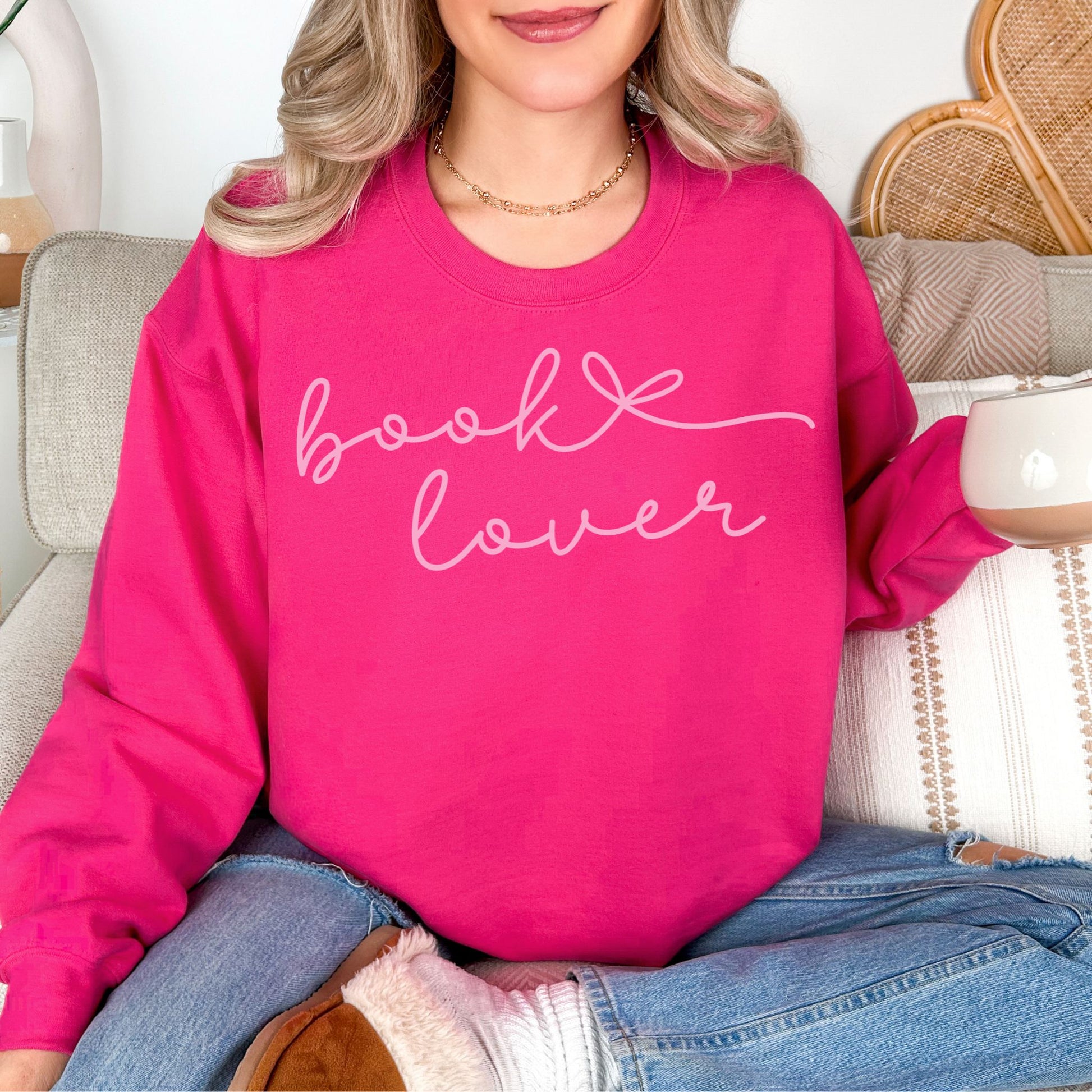 "Book Lover" graphic on bright pink (heliconia) sweatshirt.