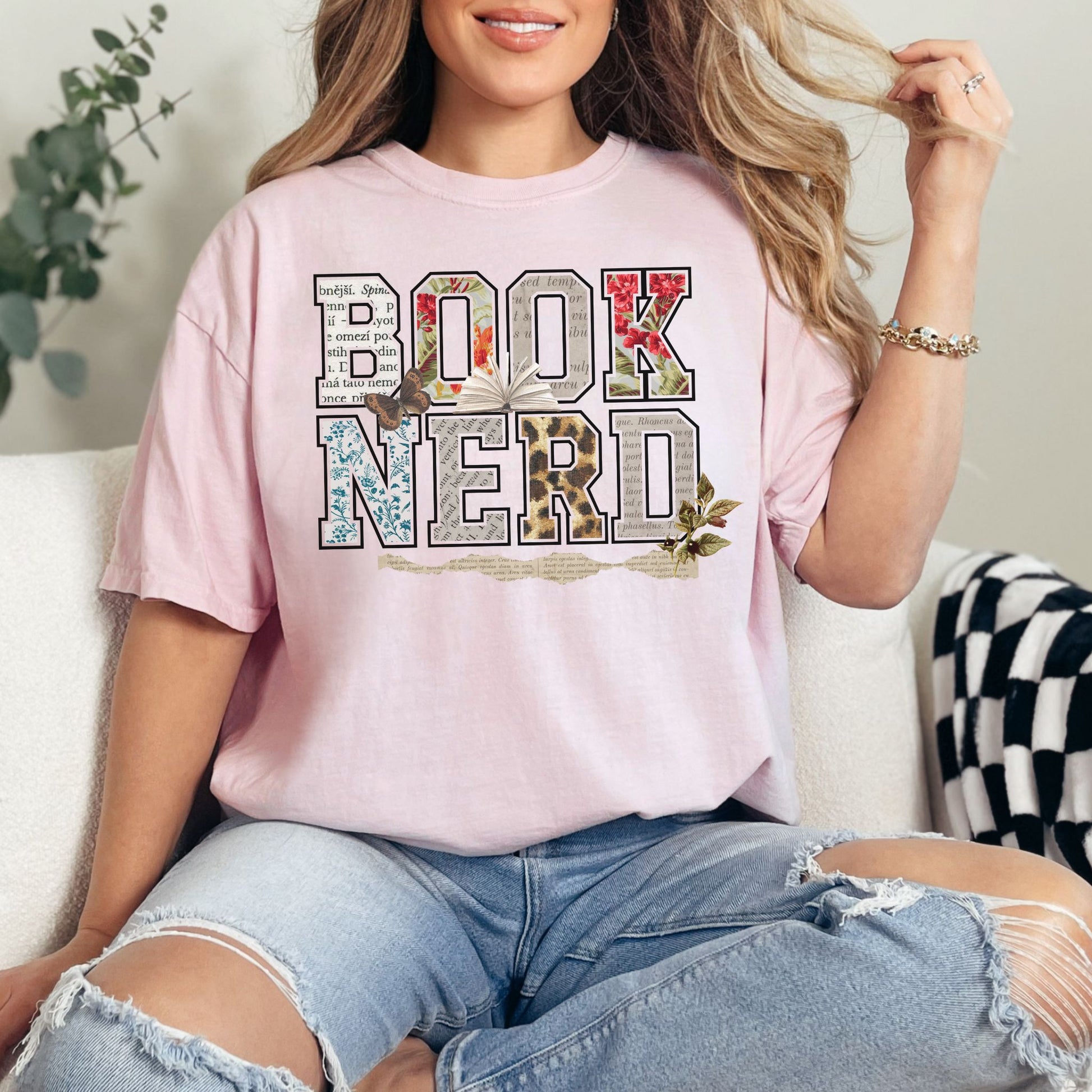 "Book Nerd" graphic on a soft pink (blossom) t-shirt.