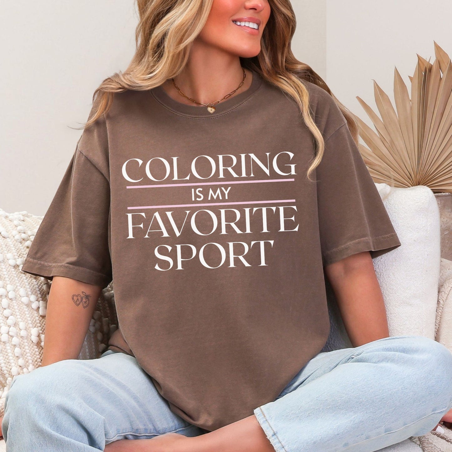 “Model wearing a Comfort Colors 1717 t-shirt in a rich brown (espresso) color featuring the graphic saying, "coloring is my favorite sport."