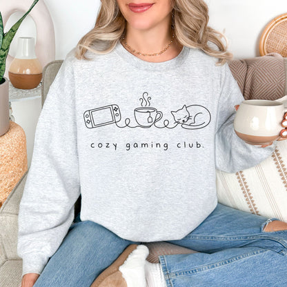 "Cozy gaming club" graphic on very light gray (ash) sweatshirt.