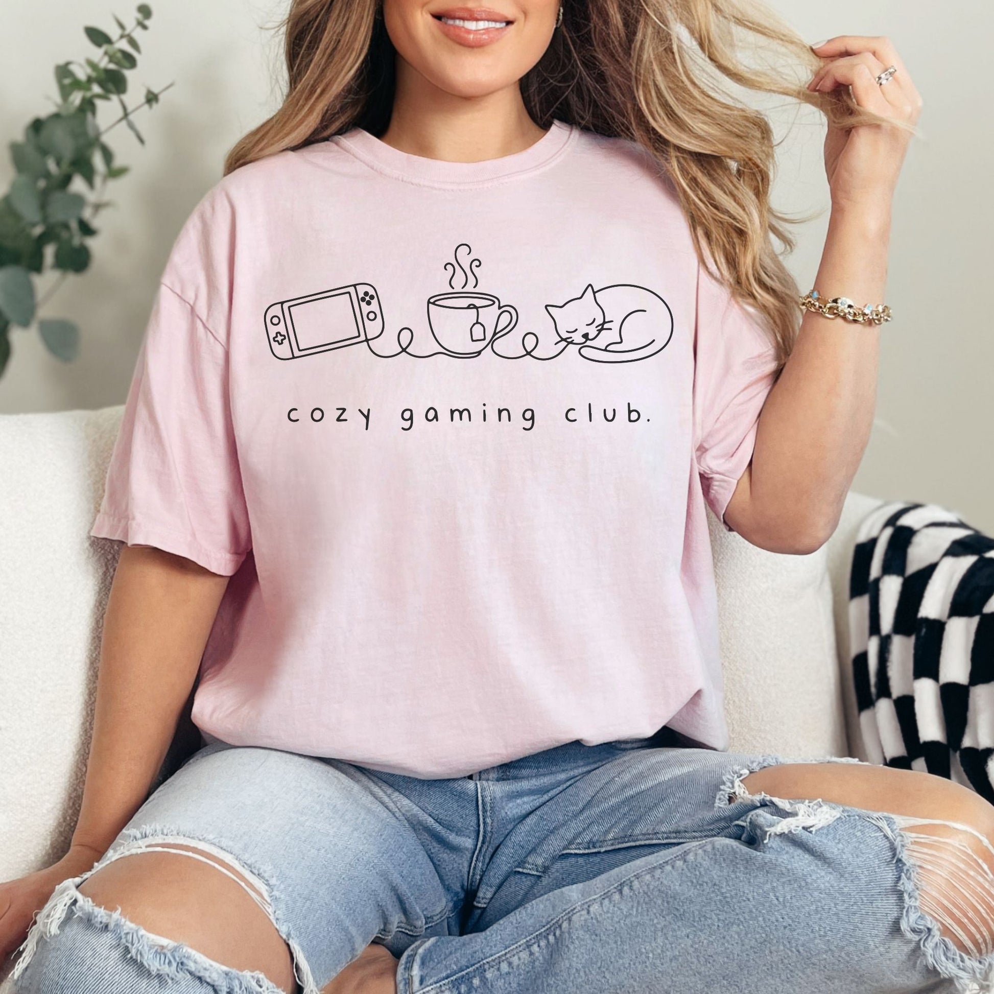"Cozy gaming club" graphic on soft pink (blossom) t-shirt.