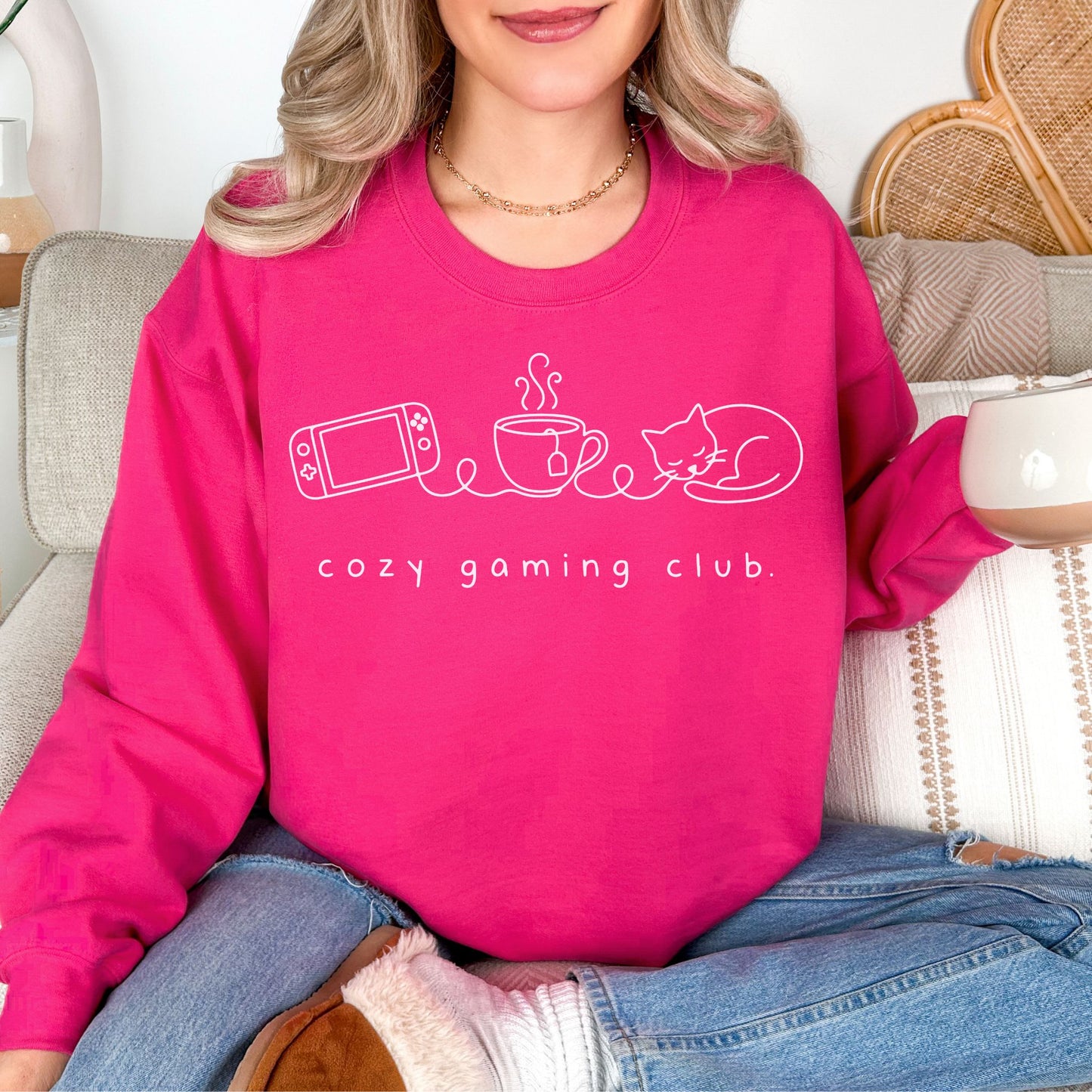 "Cozy gaming club" graphic on bright pink (heliconia) sweatshirt.