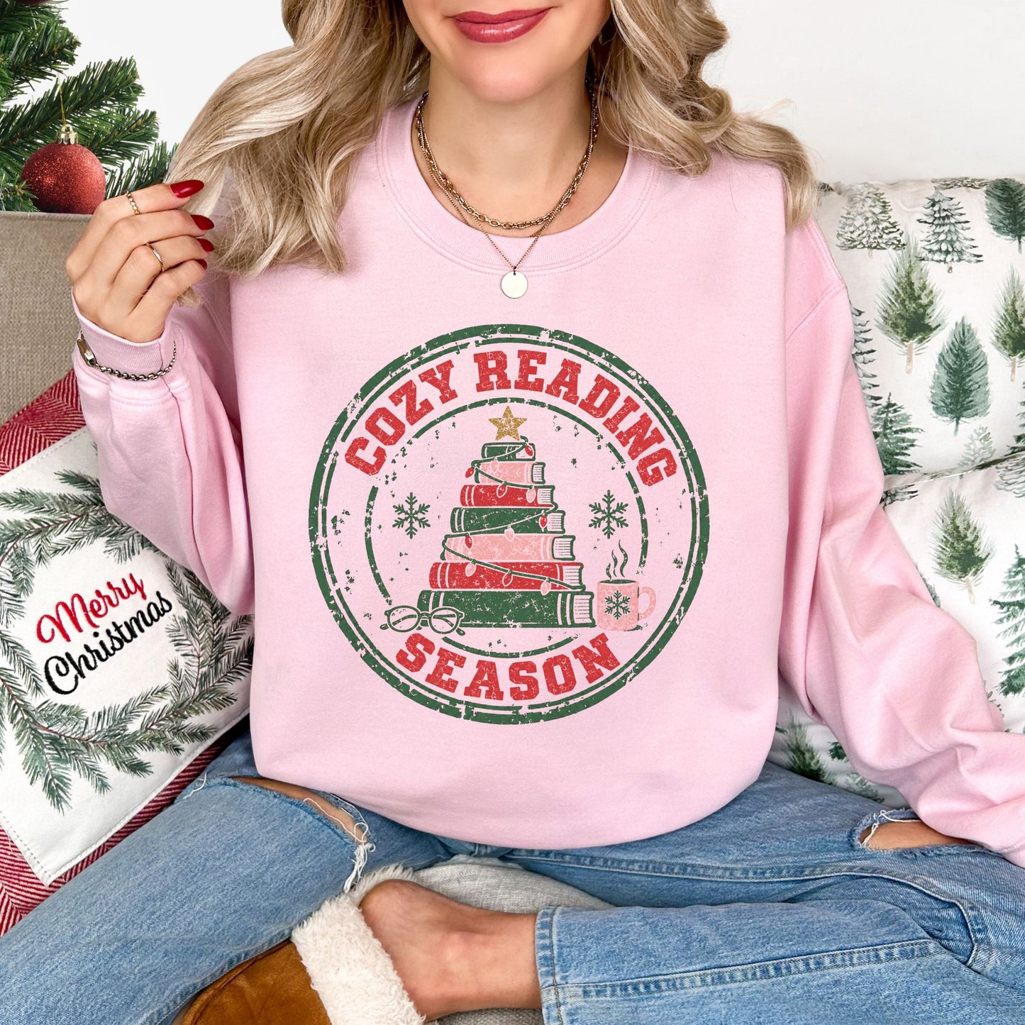 "Distressed Cozy Reading Season" graphic on a Gildan 18000 Sweatshirt in soft pale pink (light pink).
