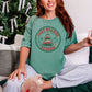 "Distressed Cozy Reading Season" graphic on a soft light green (light green) Comfort Colors 1717 T-Shirt. 