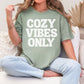 "Cozy vibes only" graphic on muted teal-green (bay) T-shirt.