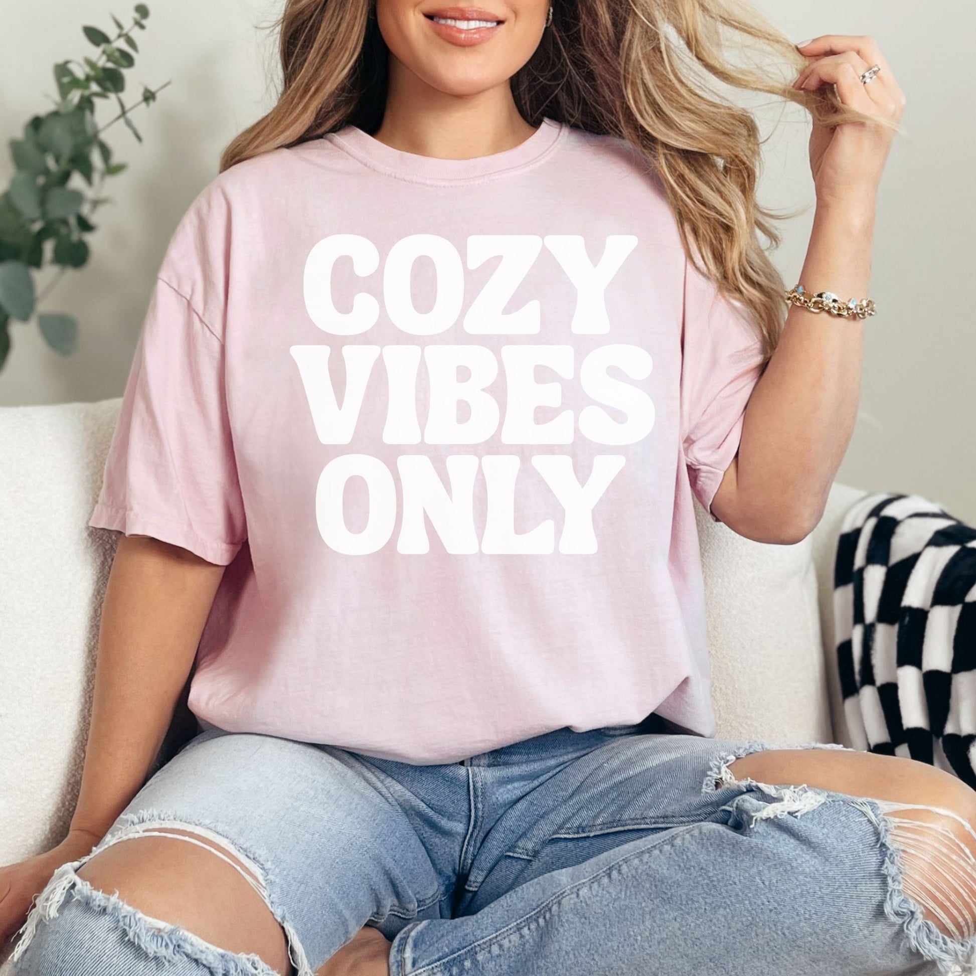 "Cozy vibes only" graphic on soft pink (blossom) T-shirt.