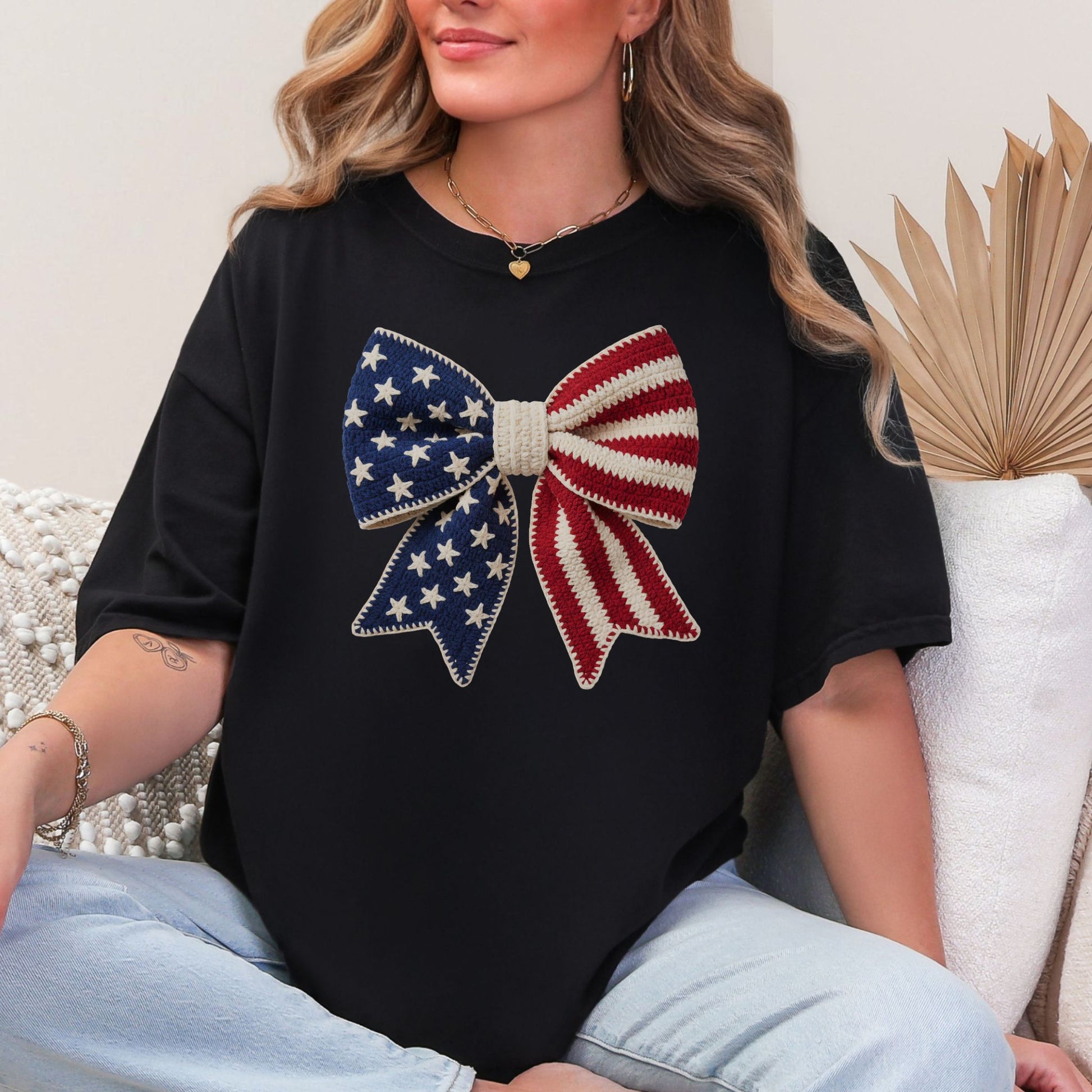 Faux Crochet American Flag Bow" graphic on a black T-Shirt.