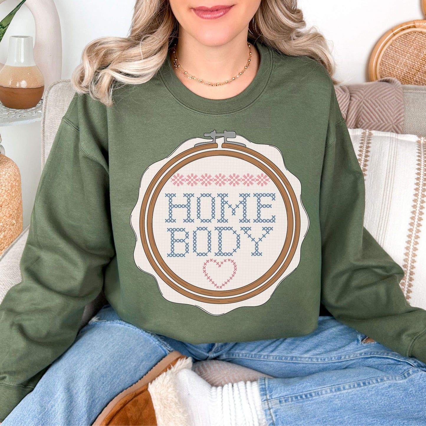 Cross Stitch Home Body graphic on muted olive green (military green) sweatshirt.