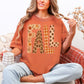 "Distressed Fall Floral Leopard graphic" on muted burnt orange (yam) Tshirt.