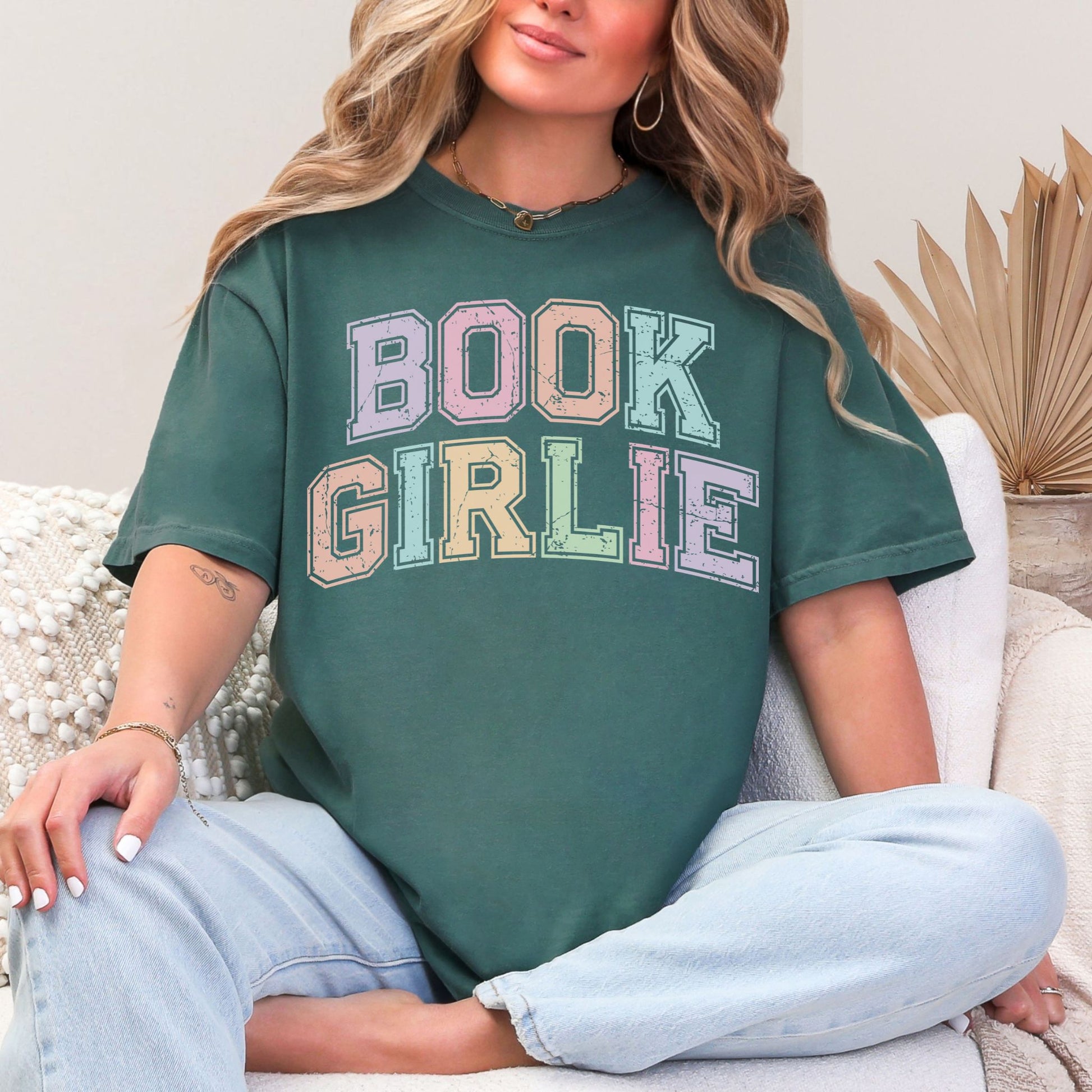 "Distressed Pastel Book Girlie" graphic on muted blue-green (blue spruce) t-shirt.