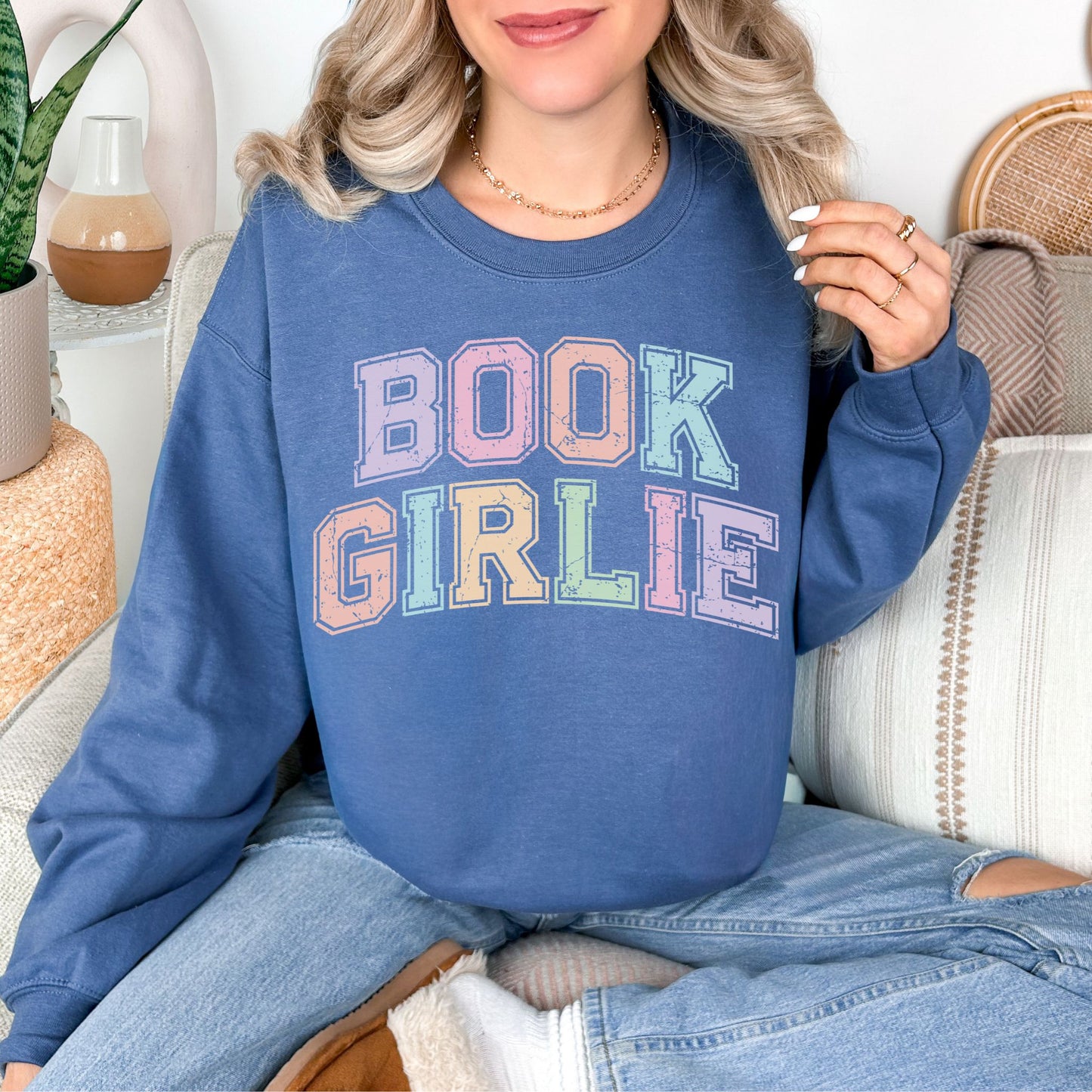 "Distressed Pastel Book Girlie" graphic on rich medium-dark blue (indigo blue) sweatshirt.