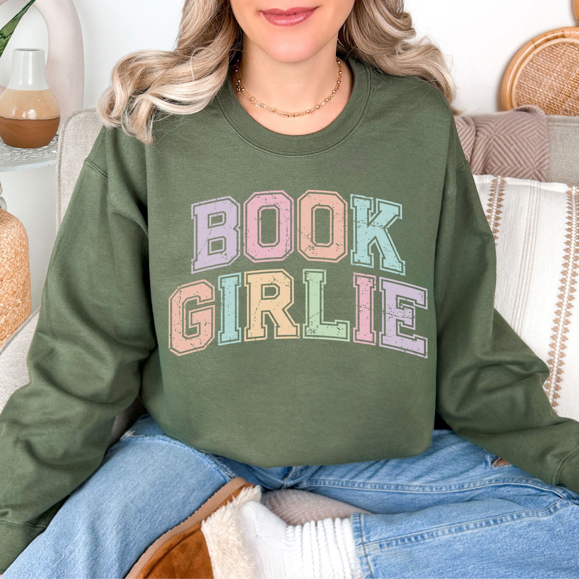 "Distressed Pastel Book Girlie" graphic on muted olive green (military green) sweatshirt.