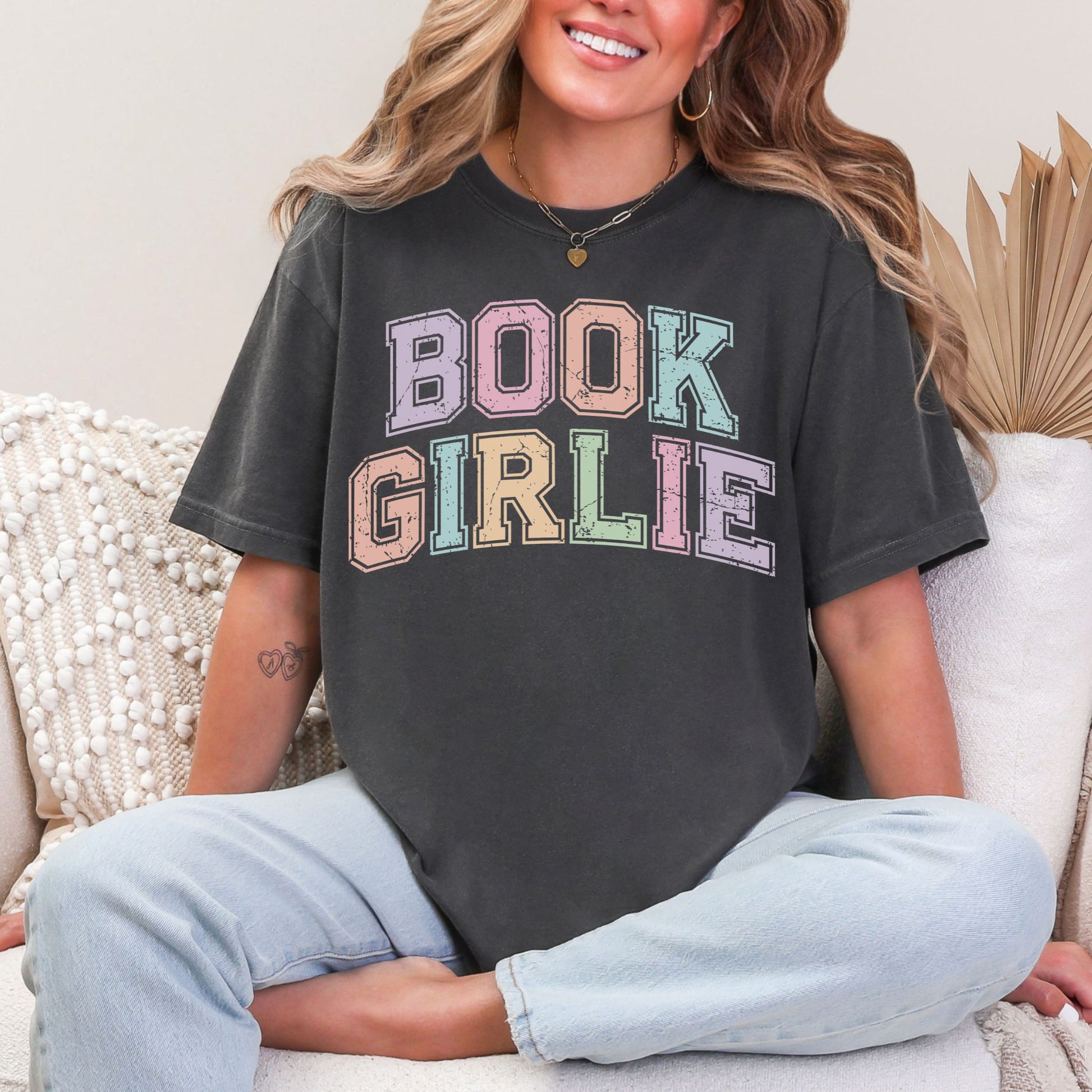 "Distressed Pastel Book Girlie" graphic on dark charcoal gray (pepper) t-shirt.