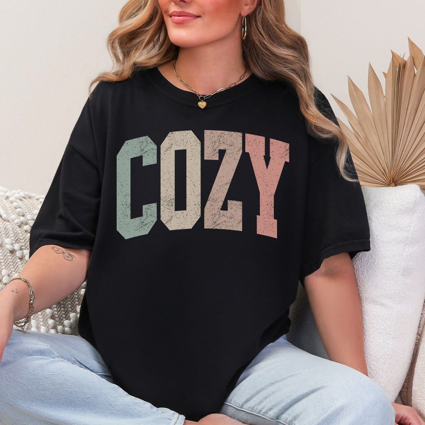 "Distressed Pastel Cozy" graphic on black T-Shirt. 