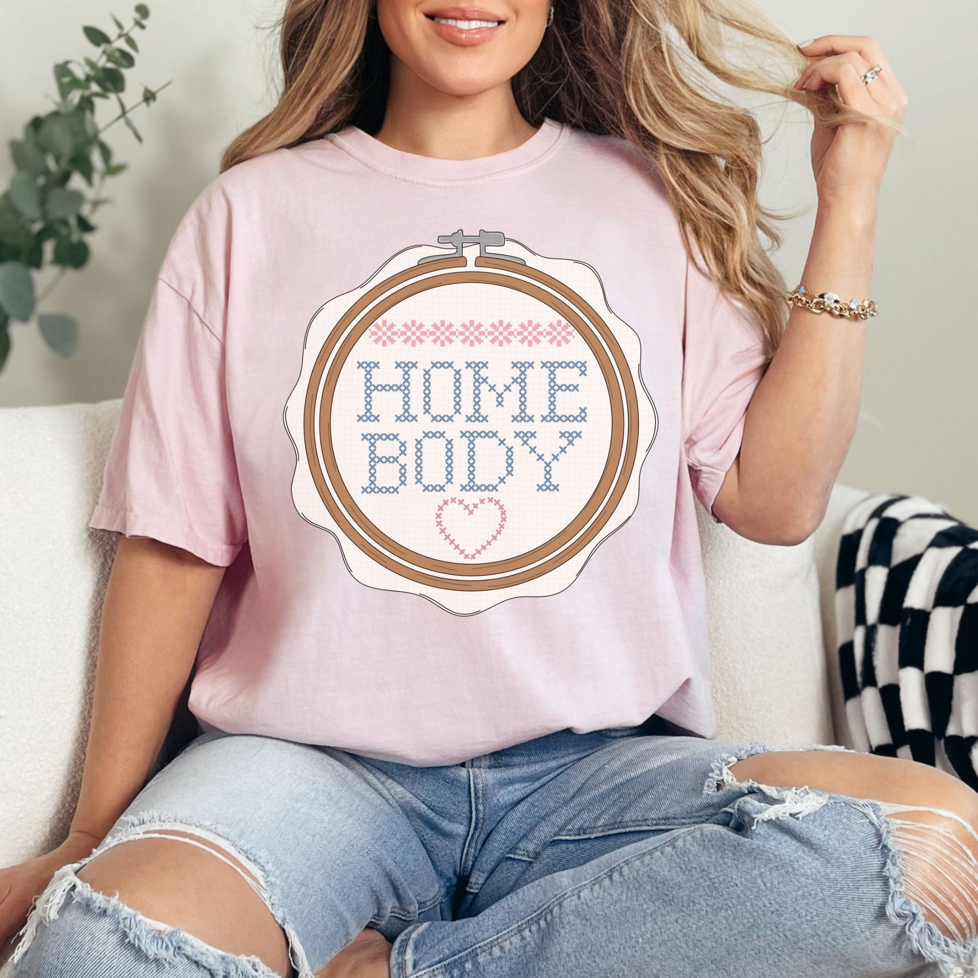 “Embroidery Hoop Home Body" graphic on soft pink (blossom) t-shirt.”