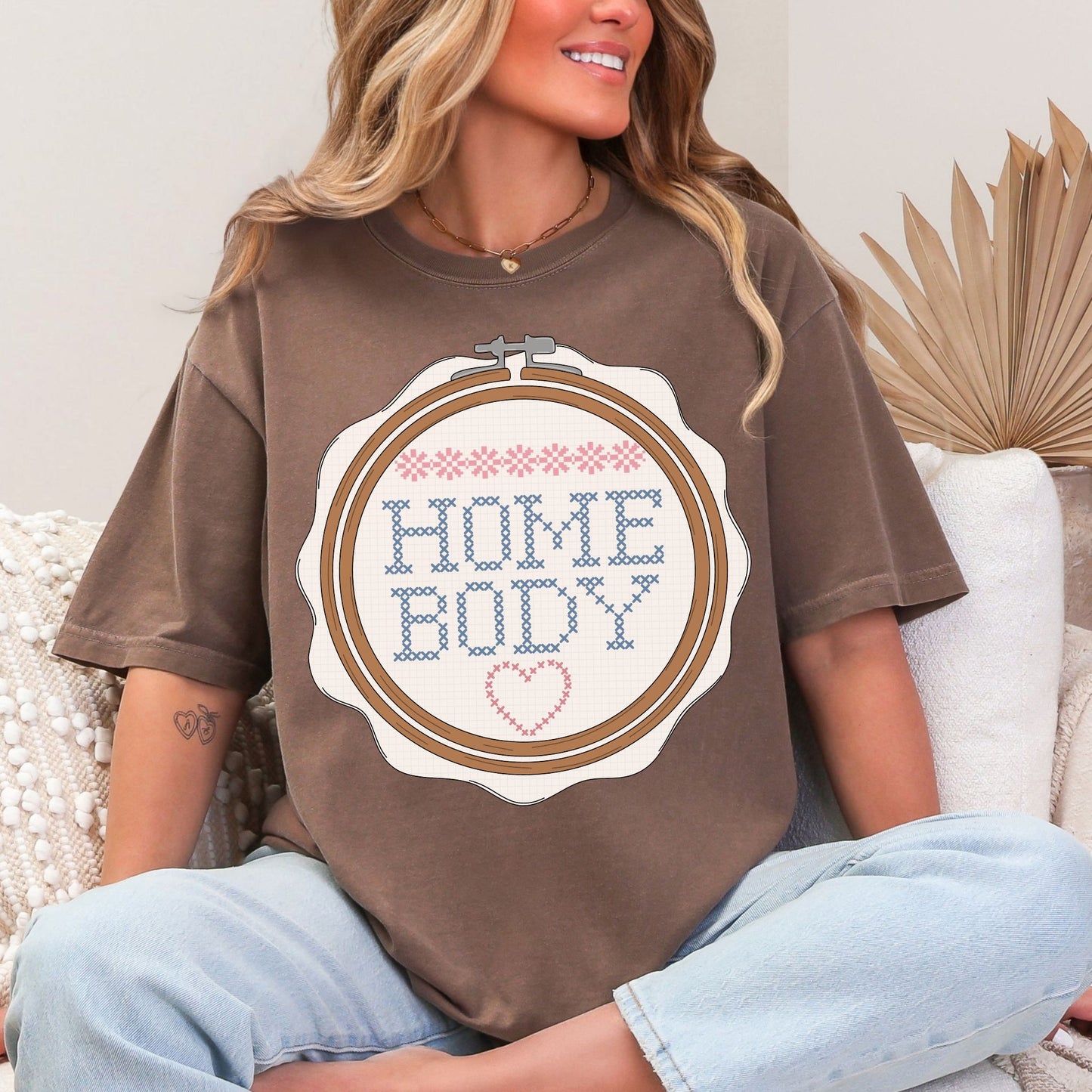 “Embroidery Hoop Home Body" graphic on rich brown (espresso) t-shirt.”
