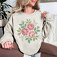 "Faux Cross Stitch Roses" graphic on light warm beige (sand) sweatshirt.