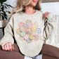 "Faux Spring Patchwork Flower" graphic on light warm beige (sand) Sweatshirt.