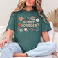 "Hobby Hoarder" graphic on muted blue-green (blue spruce) t-shirt.