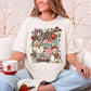 "Holly Jolly Collage" in soft off-white (ivory) on a Comfort colors 1717 T-shirt.