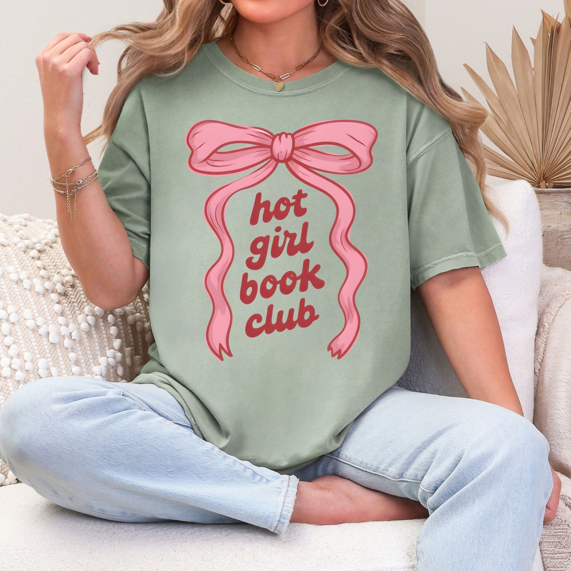 "Hot girl book club" graphic on a muted teal-green (bay) t-shirt.