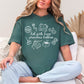 "Hot girls have grandma hobbies" graphic on muted blue-green (blue spruce) t-shirt.