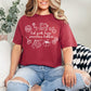 "Hot girls have grandma hobbies" graphic on muted brick red (chili) t-shirt.