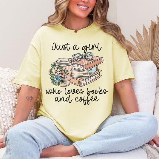 Model wearing a Comfort Colors 1717 t-shirt in a soft pastel yellow (banana) featuring a neutral colored graphic design of a stack of books, a to go coffee, a pair of eye glasses and florals. The cursive script reads "Just a girl who loves books and coffee".
