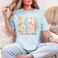 "Just One More Chapter" graphic on soft medium blue (chambray) t-shirt.