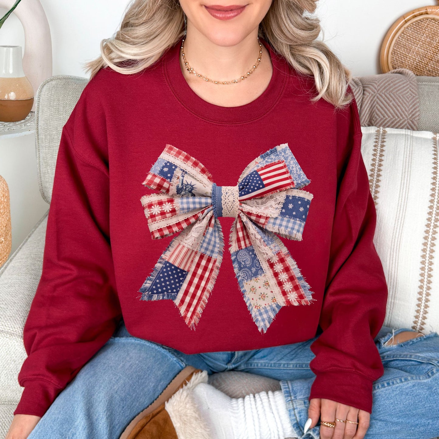 “Patriotic Patchwork Faux Bow" graphic on dark red (cardinal red) sweatshirt.