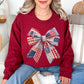 “Patriotic Patchwork Faux Bow" graphic on dark red (cardinal red) sweatshirt.