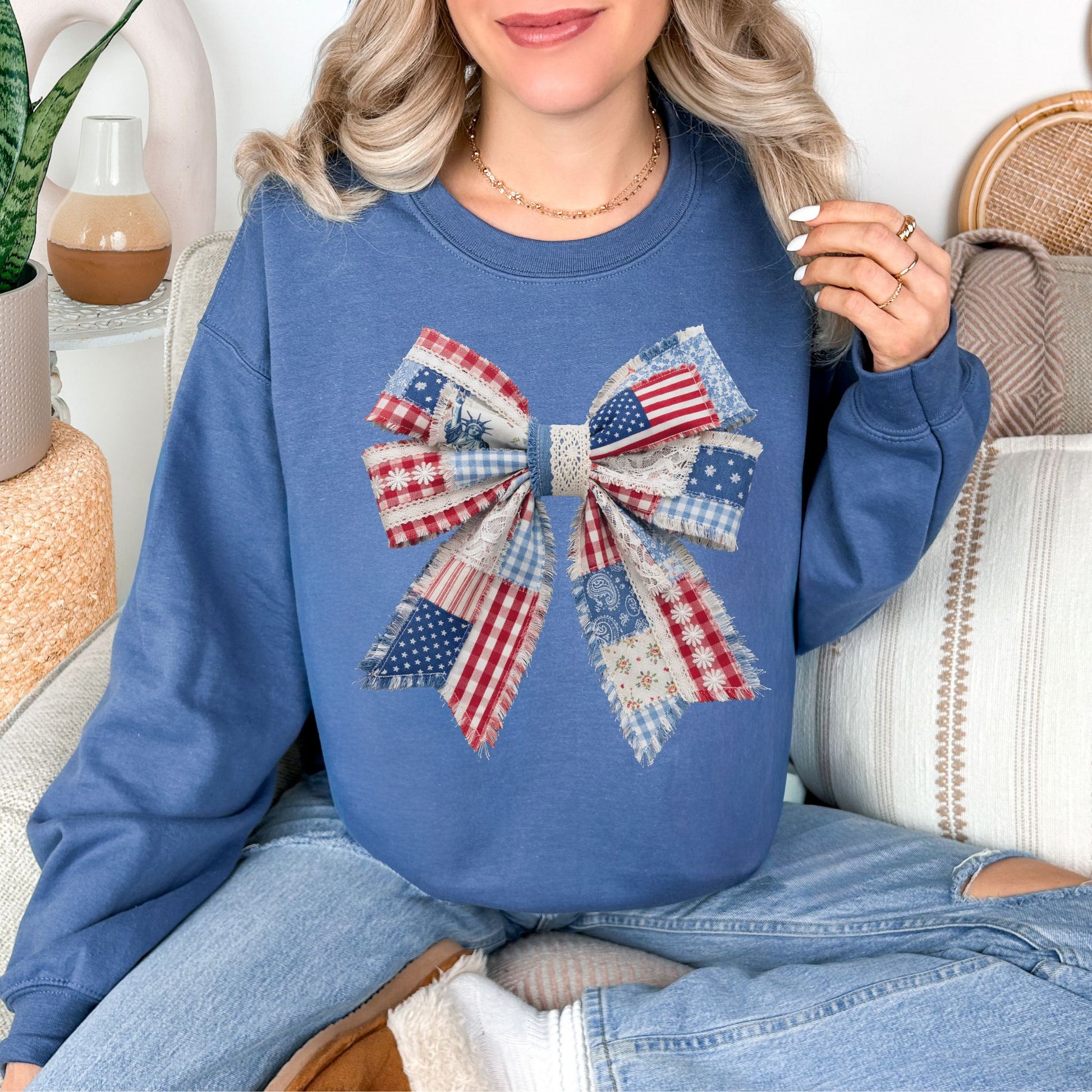 “Patriotic Patchwork Faux Bow" graphic on deep muted blue (indigo blue) sweatshirt.