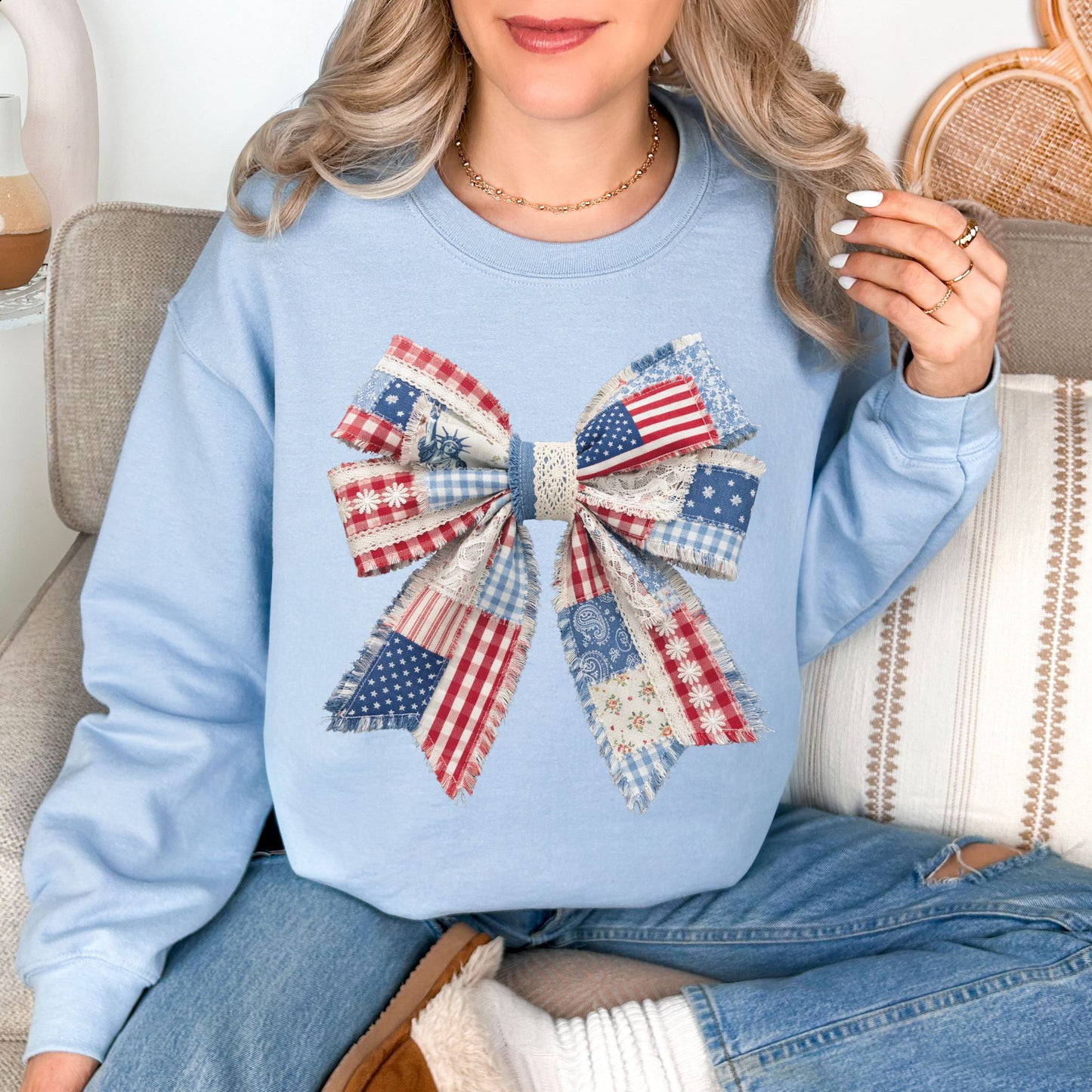 “Patriotic Patchwork Faux Bow" graphic on pale blue (light blue) sweatshirt.
