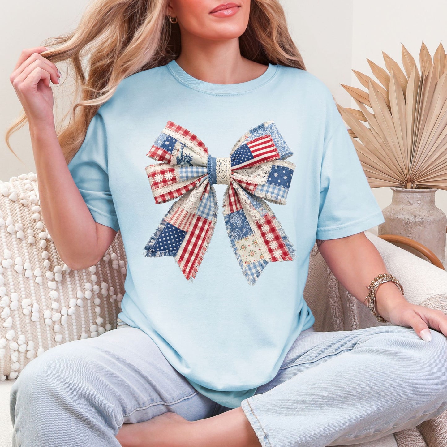 “Patriotic Patchwork Faux Bow" graphic on soft medium blue (chambray) t-shirt.