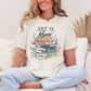"She is Mom" graphic on soft off-white (ivory) T-Shirt.