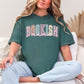 “Spring Floral Bookish Mama" graphic on muted blue-green (blue spruce) t-shirt.
