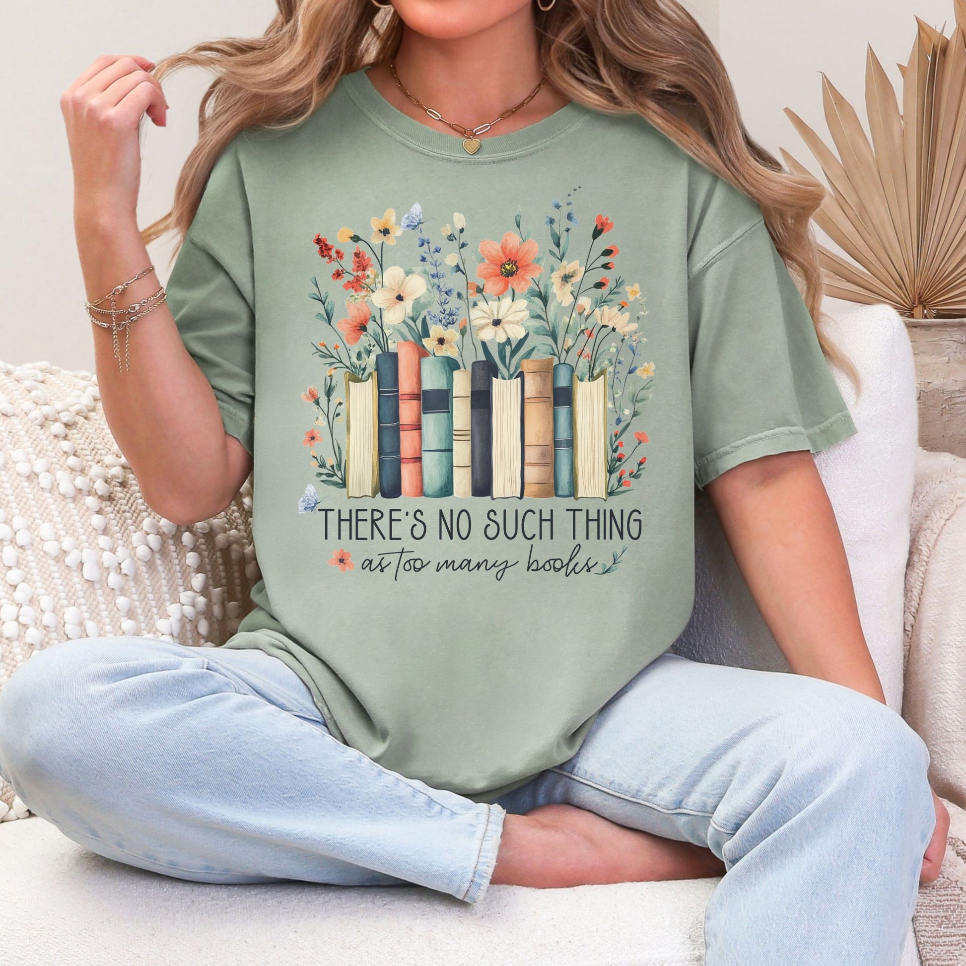 "There's no such thing as too many books" graphic on muted teal-green (bay) T-shirt.