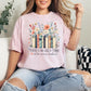 "There's no such thing as too many books" graphic on soft pink (blossom) T-shirt.