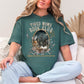 "Tired Moms Book Club" graphic on muted blue-green (blue spruce) t-shirt.