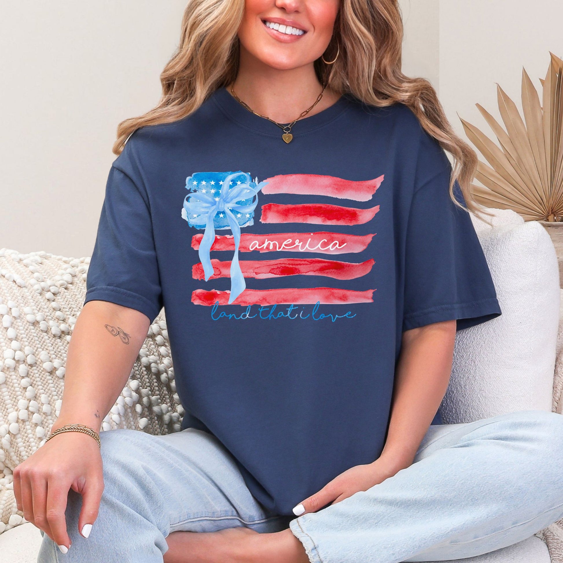 "Coquette Watercolor American Flag" graphic on deep navy blue (navy) T-shirt.
