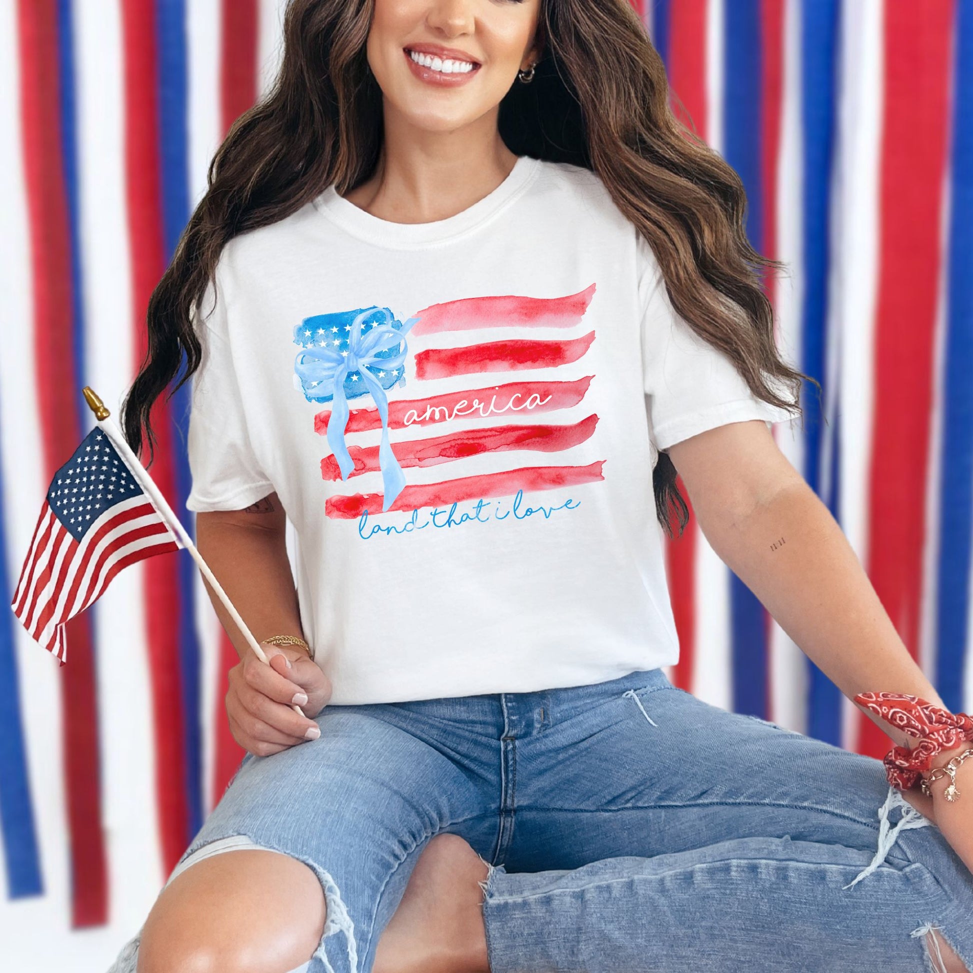 "Coquette Watercolor American Flag" graphic on a white T-shirt.